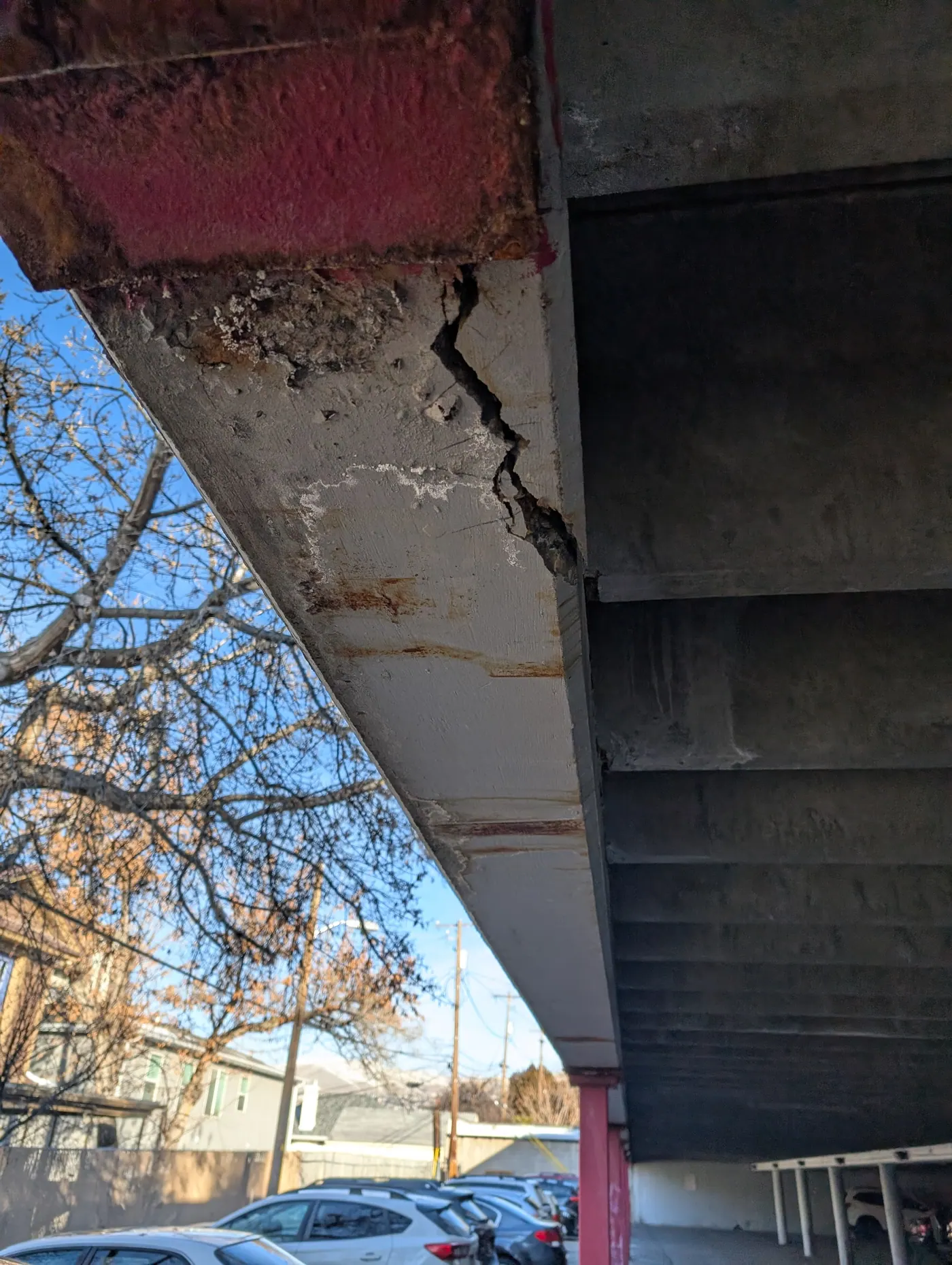 Spalled concrete and corroded reinforcement — Section loss at a concrete beam end with the reinforcement exposed and corroding — documented as part of a structural condition assessment