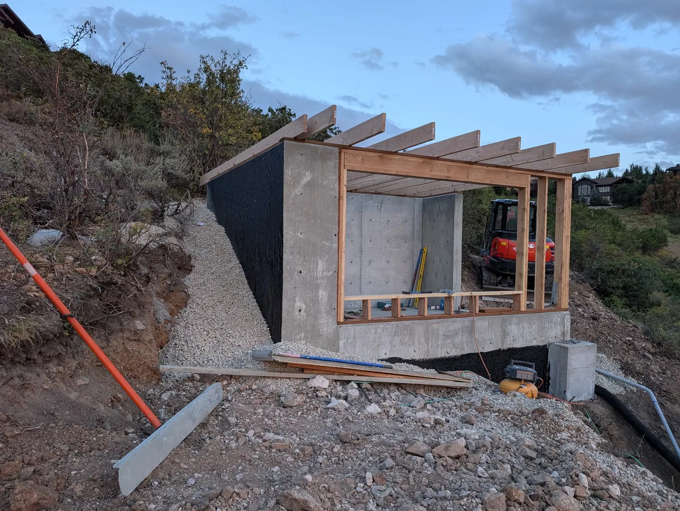 Retaining wall, waterproofing and drainage — Membrane and free-draining backfill going in behind a concrete retaining wall